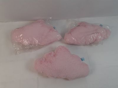 trois peluches roses dans des sacs en plastique, posées sur une table
