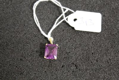 un gros plan d'un collier orné d'une pierre violette