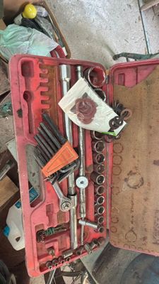 une boîte à outils contenant des outils, posée sur le sol