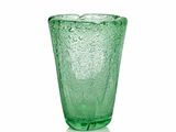 un verre vert posé sur une surface blanche