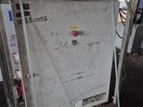 a white refrigerator sitting on a pallet in a warehouse