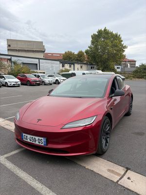 une Tesla Model S rouge garée sur un parking