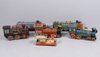 several toy trains are lined up in a row on a white surface