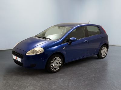 La petite voiture bleue est garée dans une pièce au sol gris.
