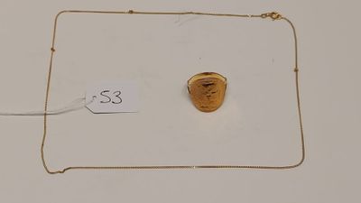 un gros plan d'un collier en or orné d'un visage