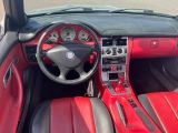 l'intérieur rouge et noir d'une voiture avec un volant