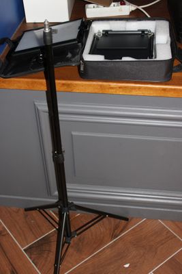 un appareil photo posé sur un trépied à côté d'un ordinateur portable posé sur un bureau