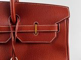 a brown leather handbag with a lock on the handle