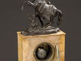 statue of a man riding a horse on a clock on a table
