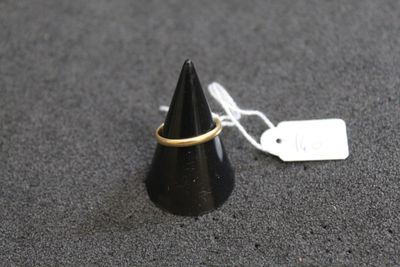 un petit cône noir orné d'un anneau doré