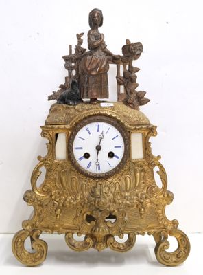 a gold clock with a statue on top of it