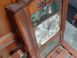 a clock that is sitting on a chair in front of a wall