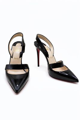 des chaussures à talons hauts noires avec des lanières, sur fond blanc