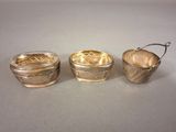three silverplated bowls with handles and handles on a table