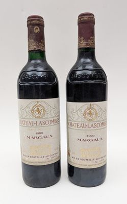 deux bouteilles de vin posées l'une à côté de l'autre sur une surface blanche
