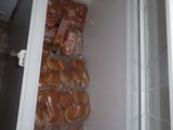 a refrigerator full of hotdogs and buns in it