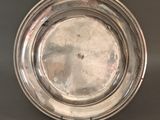 an antique silver plate on a stand on a gray background