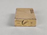 a close up of a gold lighter on a white surface