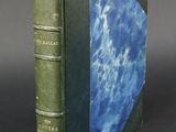 an old green book with a blue cover sitting on top of a table