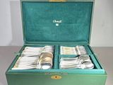 a green box with silverware in it on a table