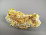 a close up of a piece of rock with yellow and white crystals
