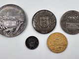 four different coins sitting on top of a table next to each other