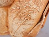 a close up of a piece of bread with a face carved into it