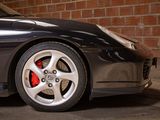 a black sports car parked in front of a brick wall