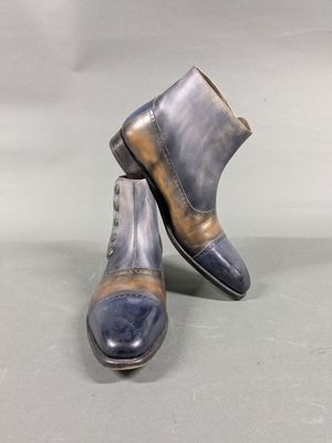 pair of men ' s blue and brown leather boots on a gray surface