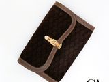 portefeuille marron et noir avec un fermoir doré sur fond blanc
