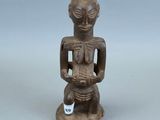 une statue ancienne d'une femme tenant un bébé dans ses bras