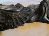 une statue en bronze représentant un oiseau avec des ailes sur le dos