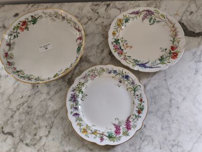 trois assiettes ornées de motifs floraux, posées sur un plan de travail en marbre