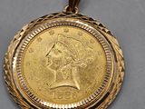 a close up of a gold coin on a white string