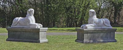deux statues représentant une femme et un homme assis sur un banc