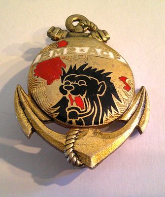 a gold pocket watch with a black and red lion on it