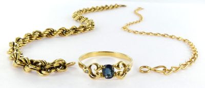 a close up of a ring and chain on a white surface