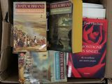 many books in a box that are sitting on a table