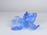 a blue glass figurine of a cat on a white surface