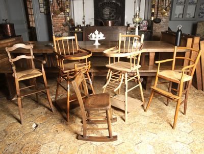 plusieurs chaises en bois et une table dans une pièce aux murs en briques
