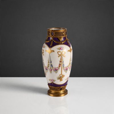 un vase violet et doré posé sur une table blanche, sur fond noir