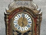 une horloge surmontée d'une statue, dans la rue