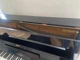 a piano that is sitting on a hard wood floor