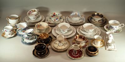 de nombreux types de tasses à thé et de soucoupes sur la table