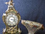 une horloge posée à côté d'un petit vase
