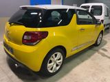 the rear end of a small yellow car parked in a garage
