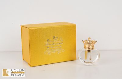 l'image d'un flacon de parfum posé à côté d'une boîte