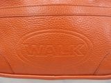 an orange leather purse sitting on top of a white table