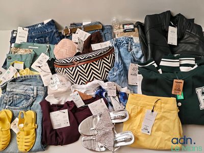 a lot of clothes and shoes that are on a table