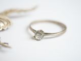 a silver ring with a diamond on it next to a chain